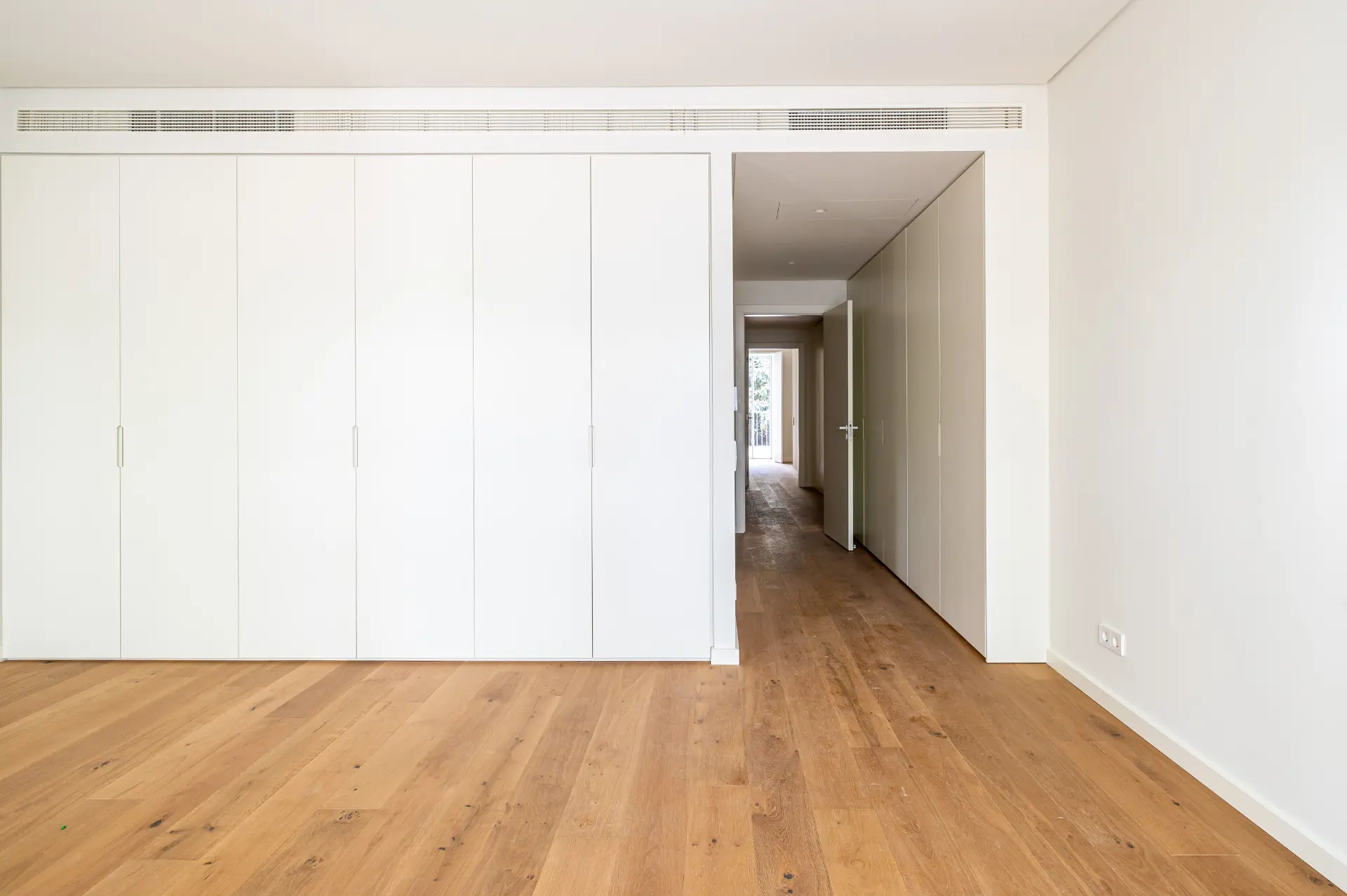 Quarto com roupeiros embutidos e soalho em madeira