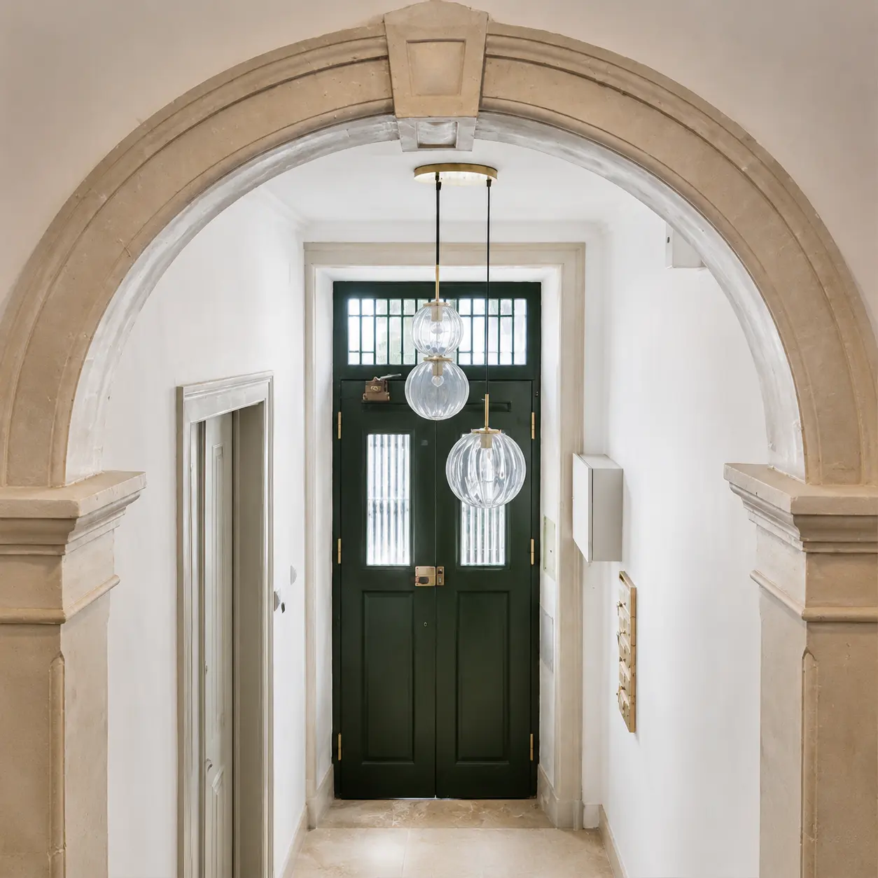Entrada do edifício com arco em pedra e porta verde